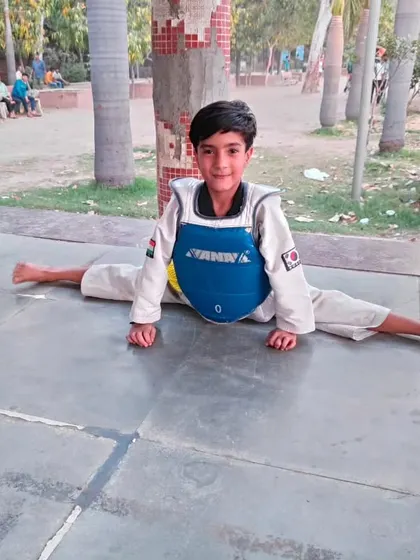 Flexibility is non-negotiable in martial arts. This young student demonstrates a perfect center split, a result of our dedicated flexibility training program which is essential for high kicks and injury prevention.