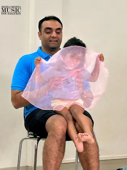 A game of peek-a-boo with a colorful scarf brings laughter and joy to our parent-toddler class, all while subtly teaching concepts like phrasing and dynamics.