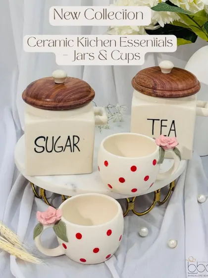 New in our collection are these charming ceramic kitchen essentials. The set includes "Tea" and "Sugar" jars with wooden lids and adorable polka dot cups with rose details on the handles.