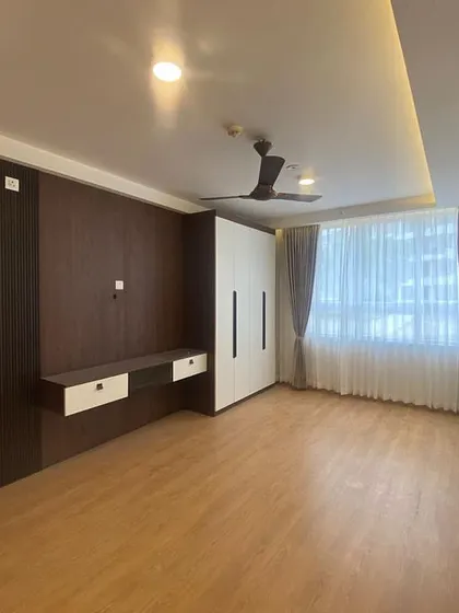 A wide shot of the bedroom, showcasing the spacious layout and the beautiful contrast between the dark wood paneling and the light-colored walls and wardrobe.