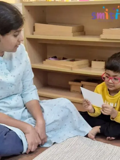 A teacher and child have a one-on-one discussion about a picture card. These individual interactions are key to assessing a child's understanding and guiding their learning journey.