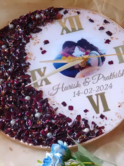 A duplicate of image 94, this is a beautiful resin clock with a half-moon of preserved red flowers and the couple's photo.
