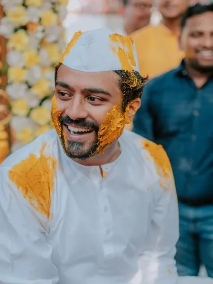 A happy, candid portrait of the groom enjoying his Haldi ceremony.