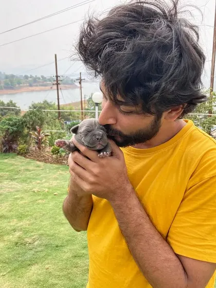 A gentle kiss for a tiny pitbull puppy. These candid shots are all about warmth and affection.