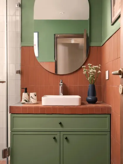In this bathroom, I paired earthy terracotta tiles with a calming sage green on the vanity and upper walls. The result is a warm, inviting space that feels both modern and timeless.