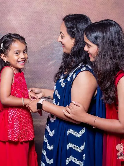 A mother shares a happy moment with her two daughters. The candid laughter and loving interaction between them make this a truly special family portrait.