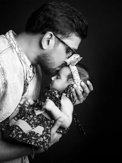 A tender black and white moment of a father kissing his baby's forehead. These unposed, candid-style shots are perfect for capturing genuine emotion.