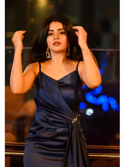 The rich navy satin of this gown looks incredible against the city lights. A perfect outfit for a glamorous night out.