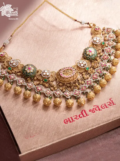 The Rajlekha Heritage Set is a golden chronicle echoing the grandeur of palaces. This choker-style bridal piece is dense with motifs, Meenakari work, and golden beads, designed to elevate ancestry and transform the wearer into a vision of royal history.