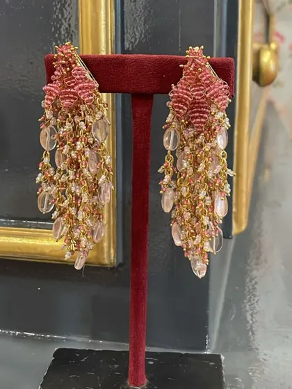A beautiful pair of our beaded tassel earrings in shades of pink, displayed to show their intricate texture and flow.