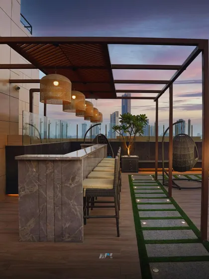 The rooftop bar at our Lower Parel project, set against the evening skyline. We used marble for the bar and warm, woven pendant lights to create a sophisticated yet relaxed entertainment space for residents.