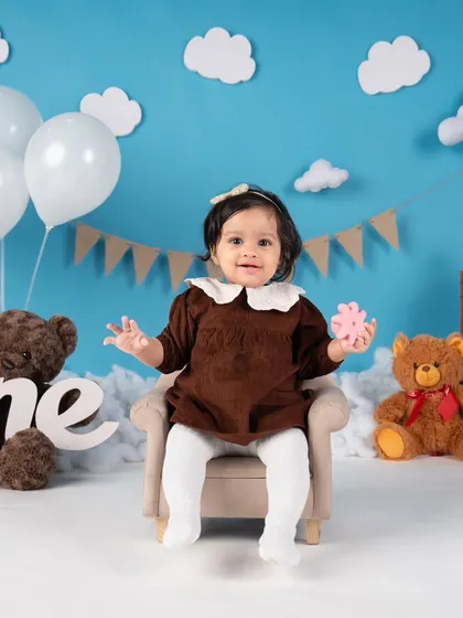 A joyful, interactive moment as the birthday girl plays on a tiny armchair. Her happiness is what these sessions are all about.