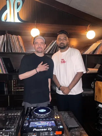 Behind the decks with a fellow DJ. Respect for the craft and for other artists is fundamental to the culture.