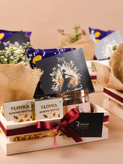 A set of the Women's Day hampers for Raphe. The combination of natural wood, jute-wrapped plants, and gourmet snacks creates a rustic yet premium feel.