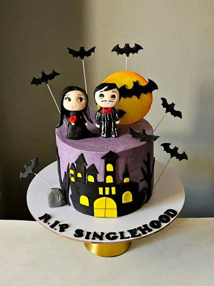 The full view of the horror-themed cake, showing how the toppers, haunted house silhouette, and bat details come together.