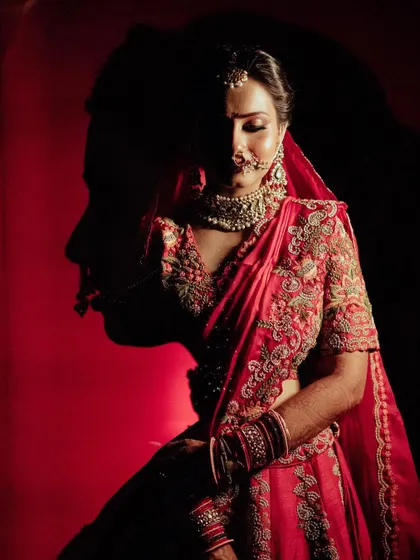 A creative double exposure portrait, where the groom's silhouette is overlaid on a stunning portrait of the bride in her red lehenga.
