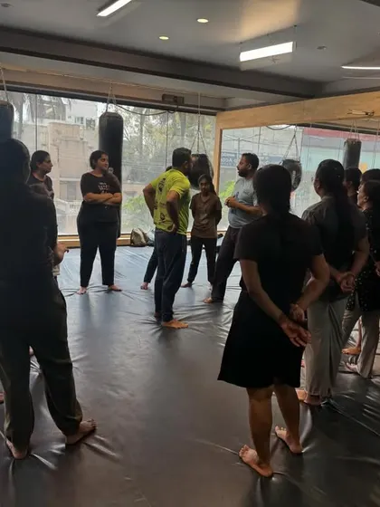 A coach addresses the group at the start of a session. We always begin by explaining the principles of situational awareness and the mindset required for effective self-defence, creating a foundation of knowledge before the physical training begins.