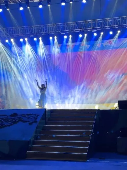 A wide shot of the stage during the Paani Foundation's dance drama, showing the beautiful lighting and set design.