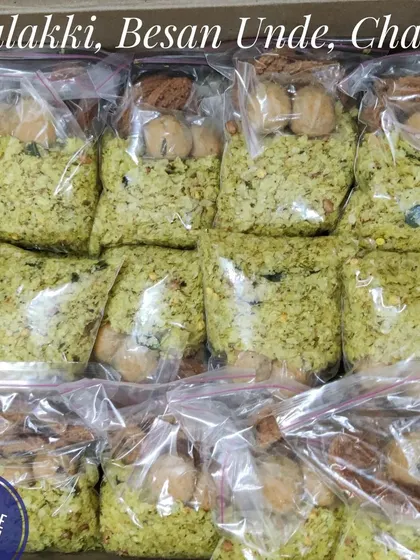 We take care in packaging your orders to ensure freshness. Here are neatly packed bags of savory Avalakki, sweet Besan Unde, and crispy Chakli prepared for a family's religious function.