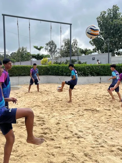 Players enjoying a game of footvolley on the sand, a fun drill that enhances ball control, teamwork, and aerial skills.