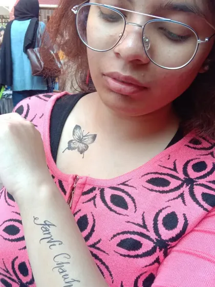 This client opted for two designs: a name tattoo on the arm and a small, detailed butterfly on the collarbone.