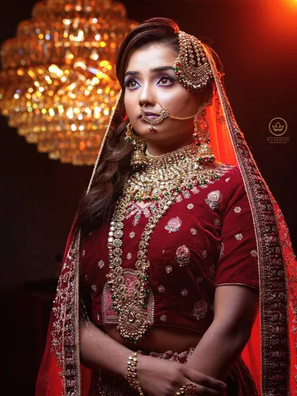 The combination of a grand chandelier and dramatic lighting enhances the regal feel of this bridal portrait. The makeup is crafted to look flawless even from a distance, ensuring you are the center of attention.
