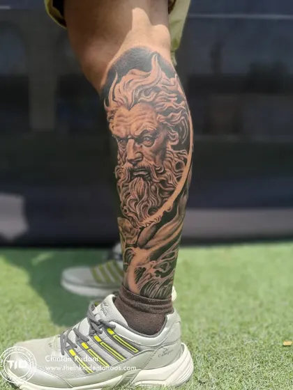 A full view of the Poseidon leg sleeve, showcasing the god of the sea amidst swirling waves. The raw, unedited photo highlights the smooth shading and realistic texture achieved in this mythological piece.