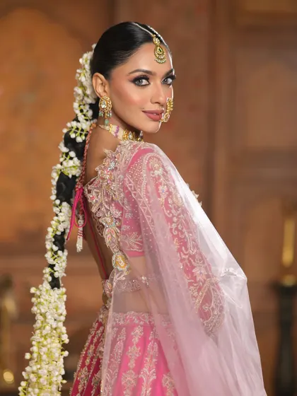 The full view of the stunning floral braid, which adds a touch of fairytale romance to the overall look. The makeup is perfectly balanced, with bold eyes and a soft lip.