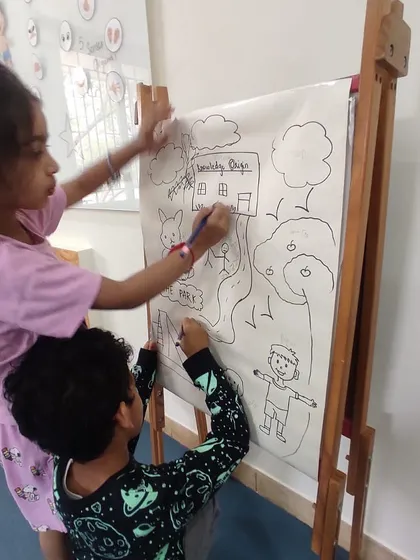 Teamwork makes the dream work! Two children collaborate on their large-scale drawing, discussing their ideas and sharing the creative process.