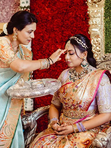 A beautiful, traditional moment as our client Nidhi receives a blessing. Her elegant ensemble, featuring our custom blouse, adds to the sanctity and beauty of the ceremony.