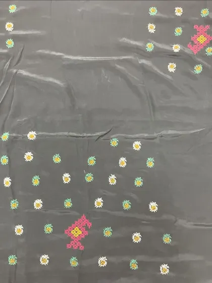 A grey silk saree with scattered floral butis and larger motifs. The pop of pink adds a contemporary feel to the traditional cross-stitch embroidery.