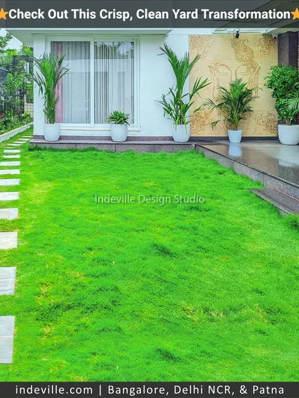 A crisp and clean backyard transformation. I laid a lush green lawn and created a simple stone path, complemented by minimalist white planters along the house for a modern and uncluttered look.