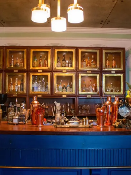 The main bar at my Khan Market location, with its classic blue wood and brass-accented liquor cabinets.