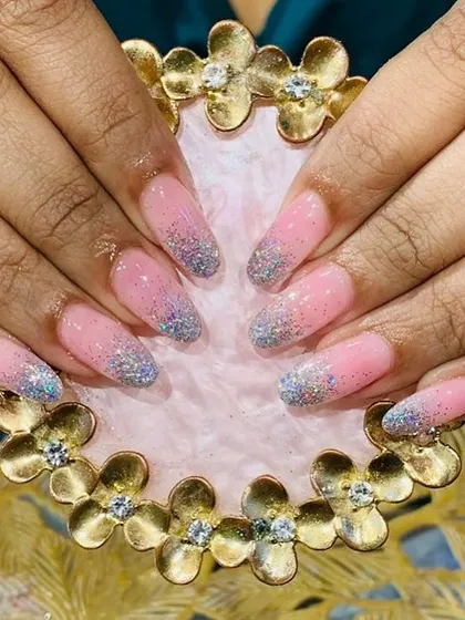 A playful pink and blue glitter gradient on long, rounded nail extensions for a touch of sparkle.