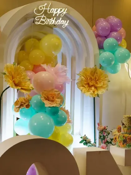 A floral garden theme with a rainbow aesthetic. The bright, cheerful colors and large paper flowers create a beautiful and happy celebration.