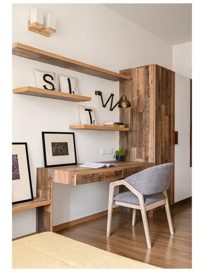 A custom-designed study nook within the daughter's bedroom, featuring a rustic wood-finish desk and shelves.