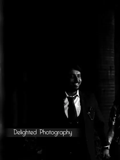 A dramatic, low-light black and white photo of the couple. The use of shadow creates a cinematic and intimate feel.