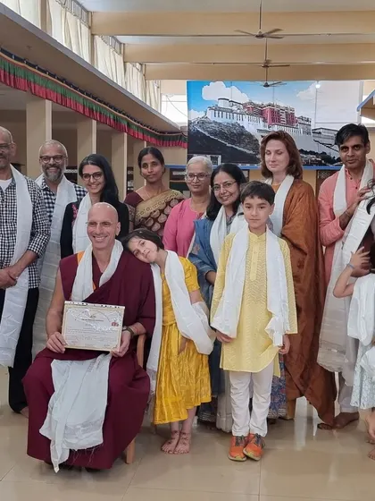 Our community group, including families and children, posing with Geshe Tenzin Legtsok. It was an auspicious and joyful time for everyone who traveled to Bylakupe for the ceremony.