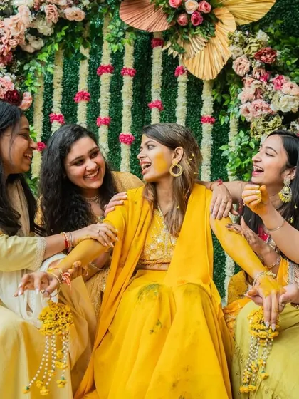 Candid moments are the best. Here, the bride and her friends share a happy moment during the Haldi ceremony, perfectly framed by the beautiful floral decor I designed.