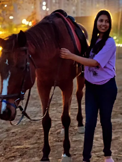 A rider gently pets her horse, a simple gesture that builds trust and friendship.