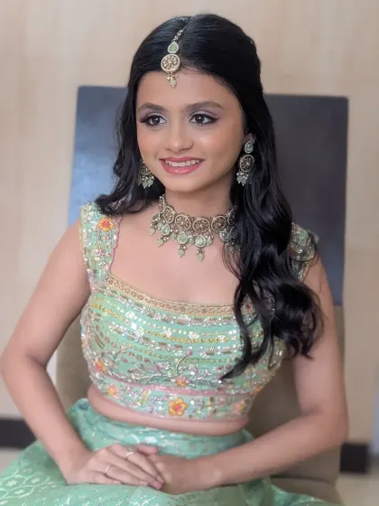 A smiling portrait from the Kirtan ceremony. The pastel green lehenga and subtle makeup create a look that is both traditional and refreshingly modern.