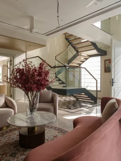 This view from the foyer looks towards the sculptural staircase, showing how we design open, flowing spaces where each area is connected yet distinct.