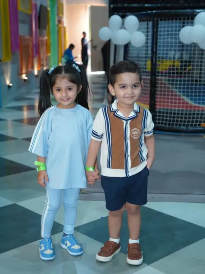 Two adorable little friends holding hands, ready for a day of adventure together.