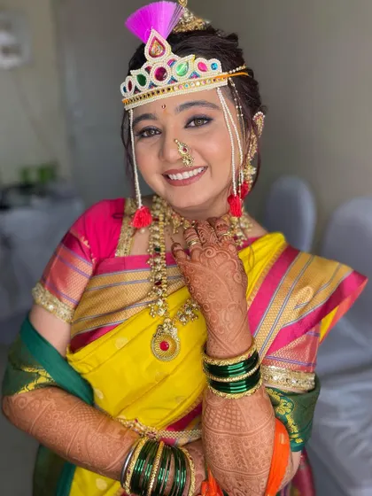 This bride's smile says it all. Her complete Marathi bridal look, from the yellow Nauvari to the colorful Bashing, is pure joy.