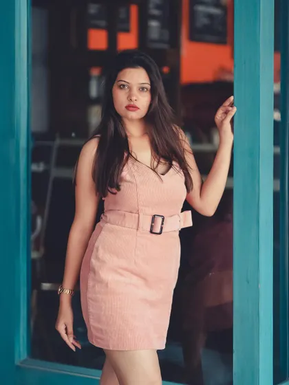 This corduroy pink dress is the star of the show. The contrasting blue door frame makes the color pop, which is a great technique for brand photography.