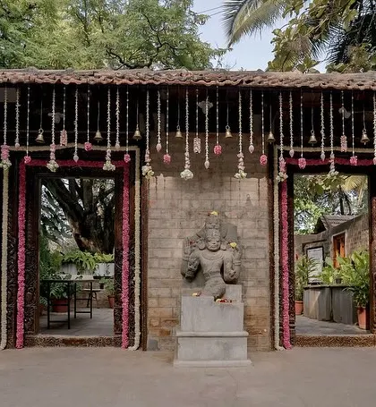 The entrance to the ceremony area, with doorways framed by pink and white floral garlands.