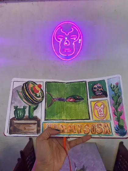 The cool neon glow of a skull sign at Sammy Sosa provides a dramatic backdrop for my sketchbook page.
