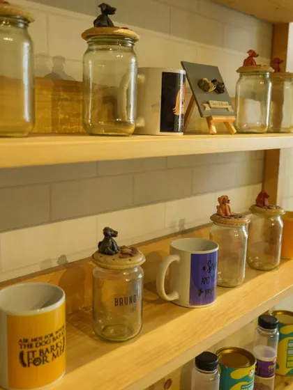 A peek at our merchandise shelf, featuring custom-lidded jars and mugs for proud pet parents. These make great additions to any gift hamper.