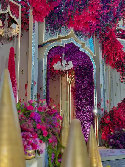 A detail of the entrance, where an archway of purple flowers creates a dramatic and inviting portal into the celebration.