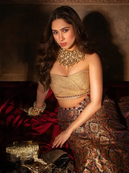 Pashmina Roshan in a full-length portrait, seated amidst luxurious fabrics, looking every bit a modern princess.
